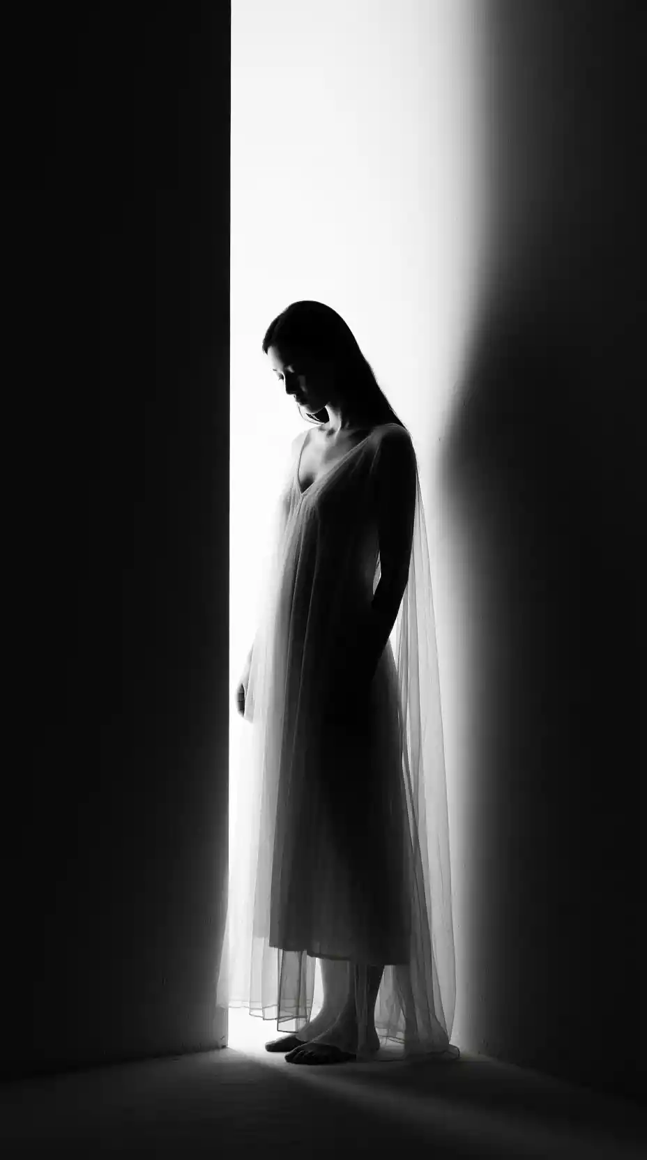 Donna in abito trasparente in una luce forte in bianco e nero