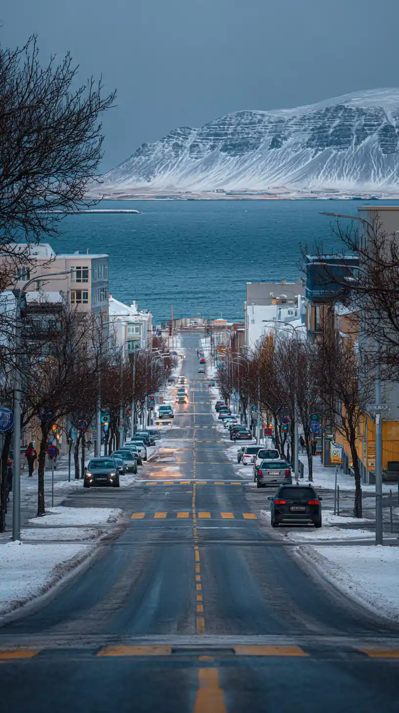 Winter city street leading straight toward a calm sea