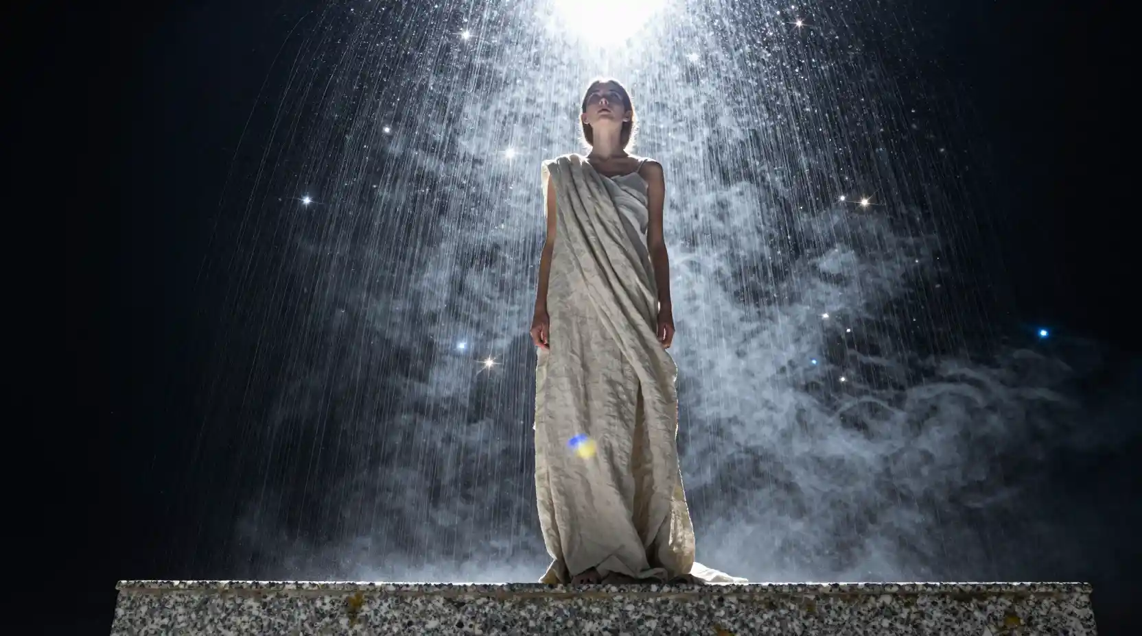 Jovem olhando para o brilho em cascata das estrelas de baixo