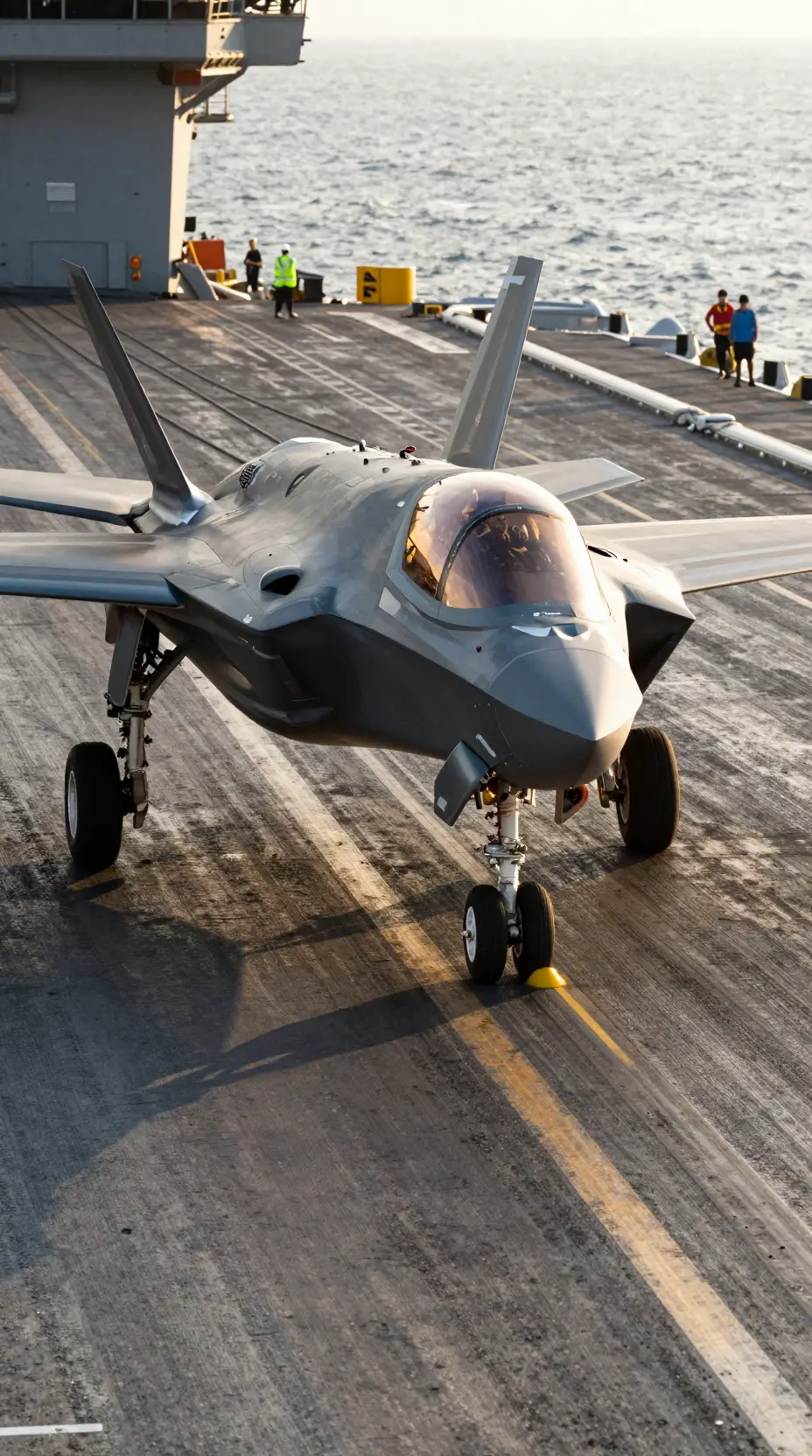 黄金色の時間帯に空母甲板へ進入するF-35C戦闘機
