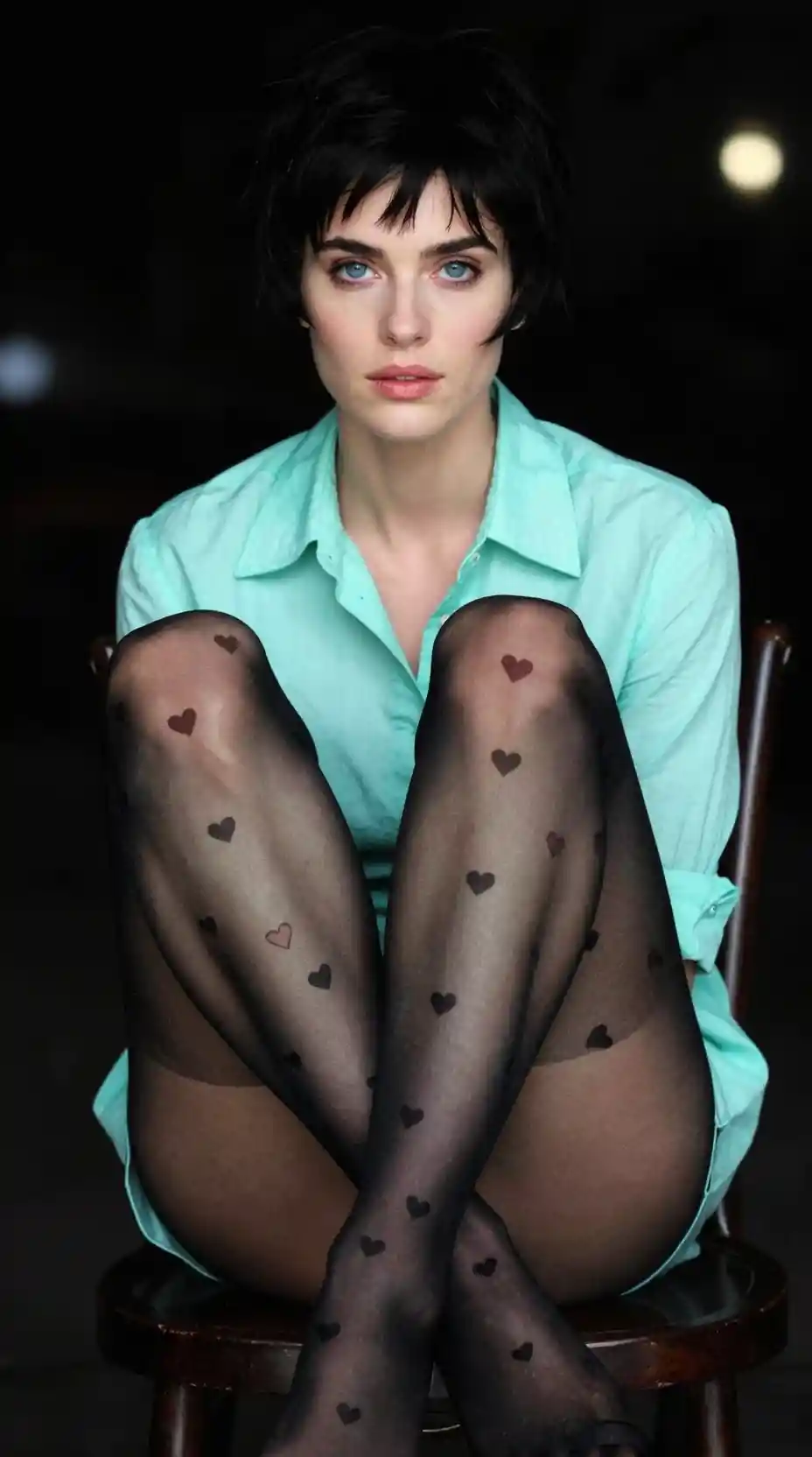 Low angle portrait of a woman in mint shirt on chair