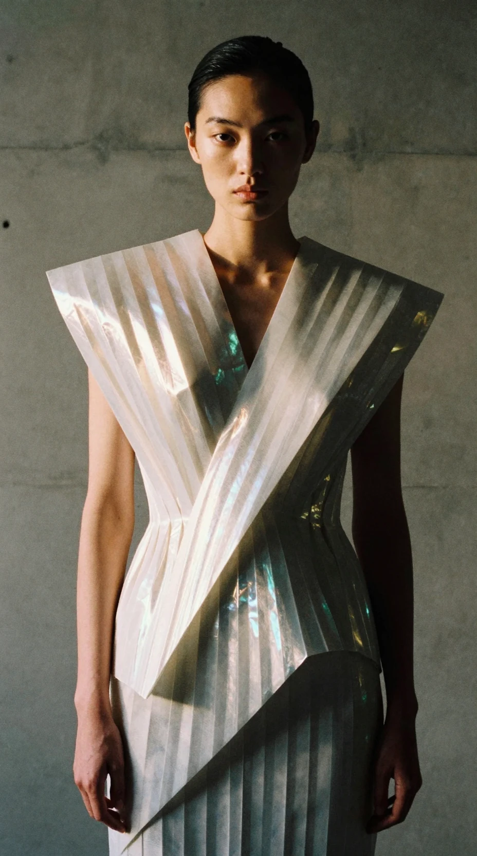 Ritratto di moda drammatico con capo plissettato iridescente scultoreo