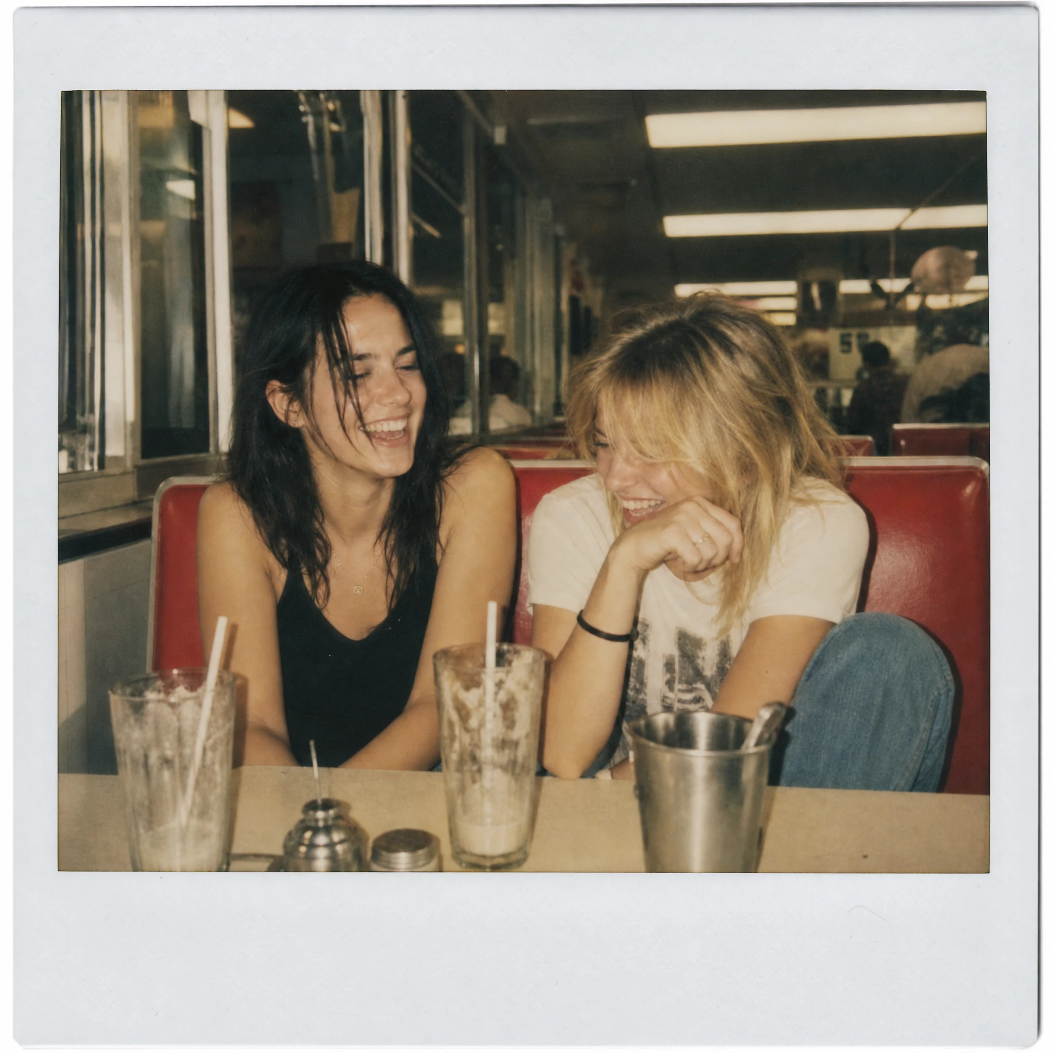 Friends Laughing Together In A Vintage Diner Booth