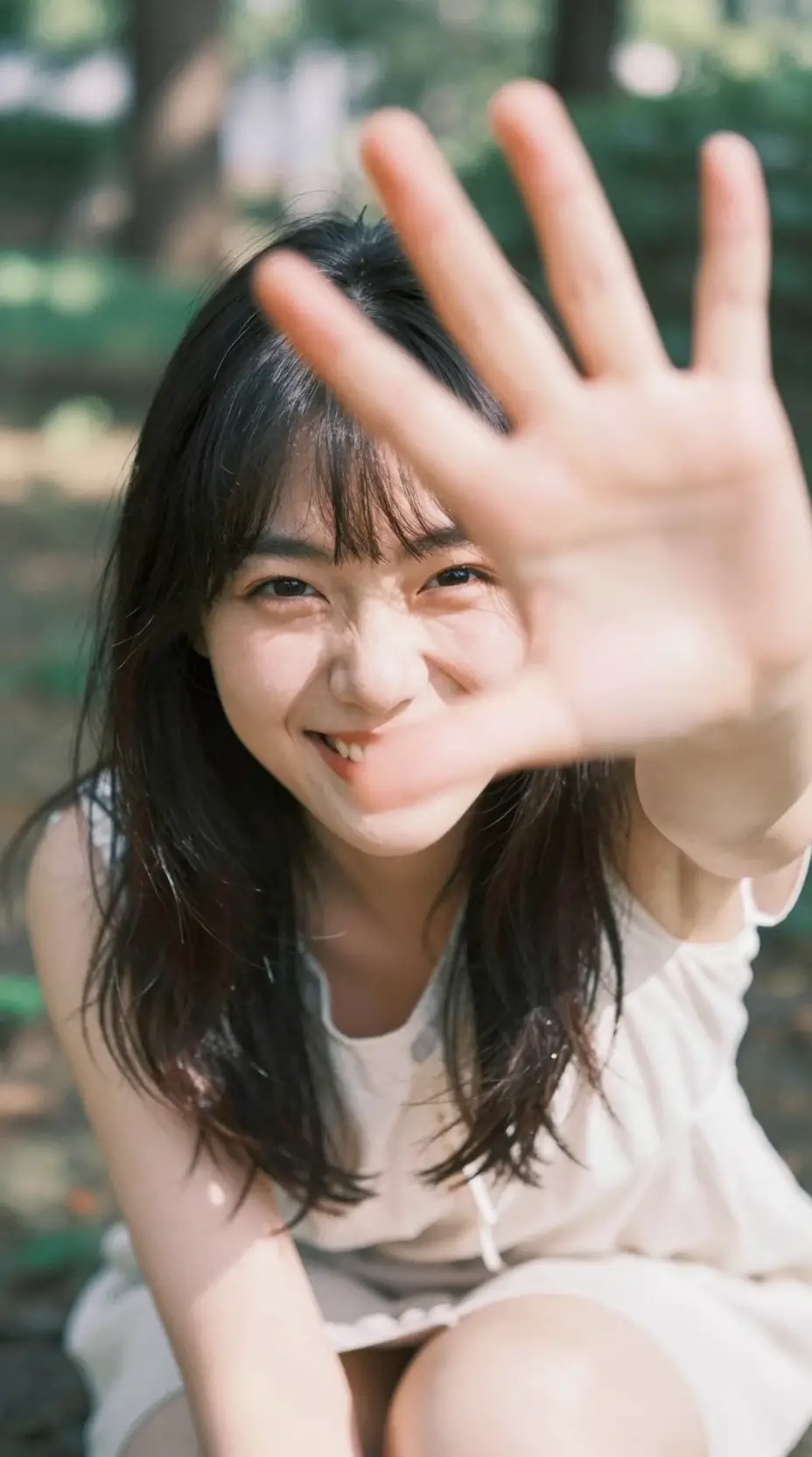 Playful japanese woman reaching toward camera in garden