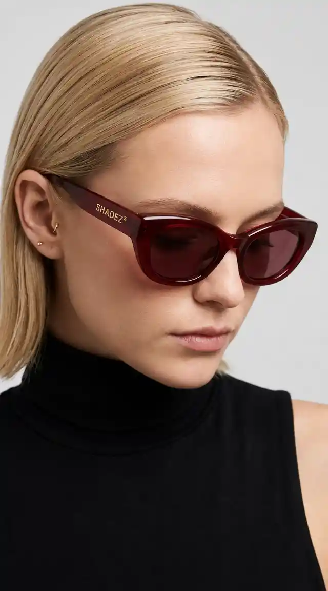 Minimalist portrait of blonde woman in crimson cat eye sunglasses