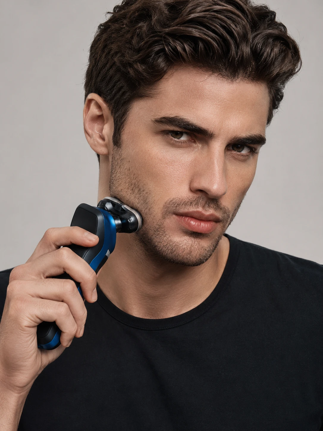 Close-up de modelo masculino se barbeando com barbeador elétrico