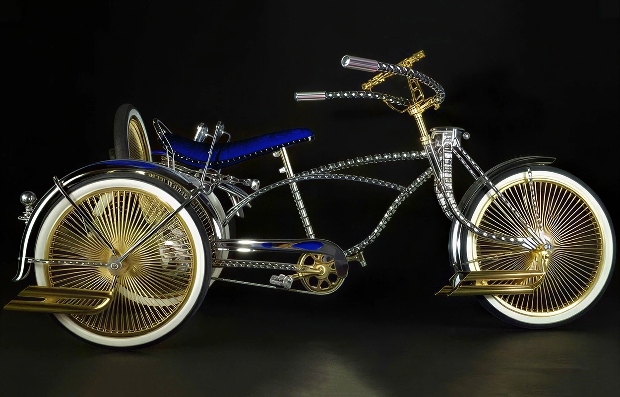 金色のディテールと青いサドルを備えたクローム・ローライダーバイク