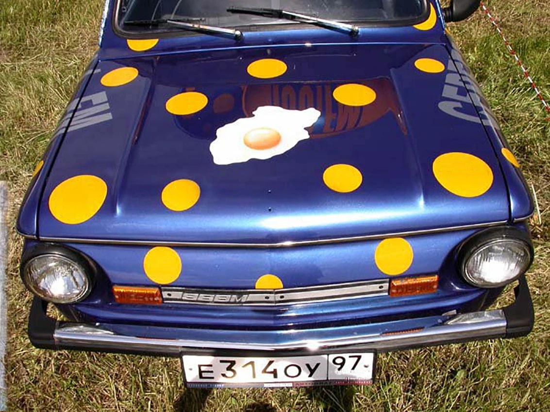 Carro azul vintage com bolinhas amarelas e capô de ovo frito