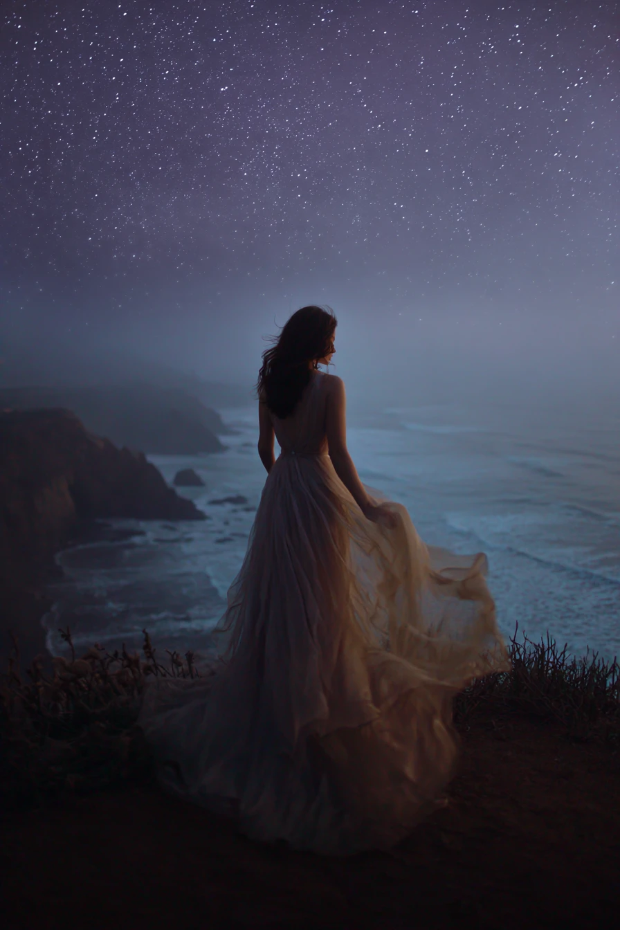 Mulher mística em um penhasco ventoso sob um céu noturno estrelado