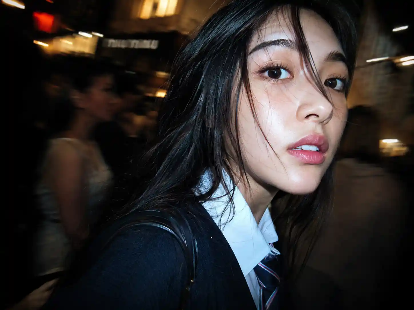 Paparazzi close up of woman in school uniform at night