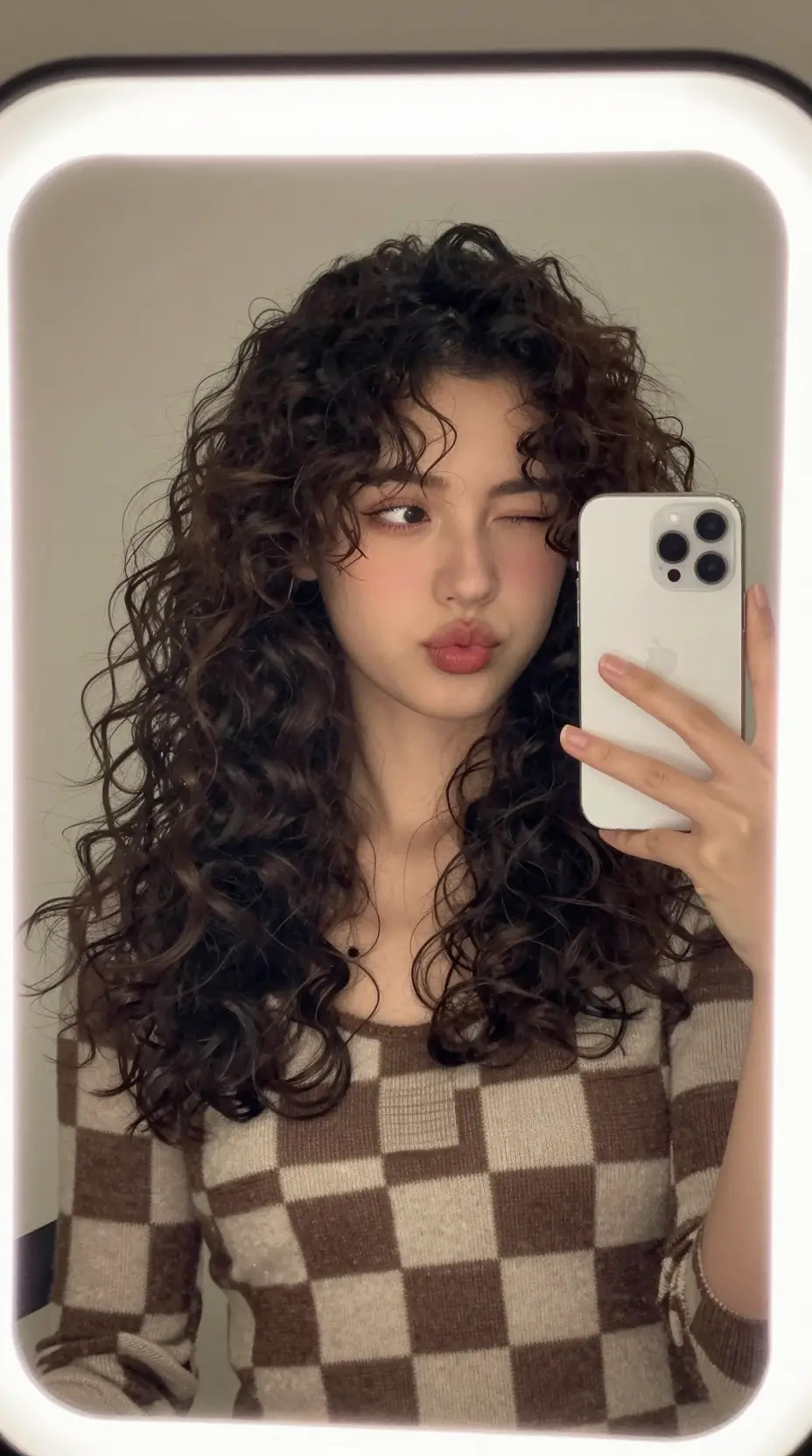 捲髮女子開心的鏡子自拍照