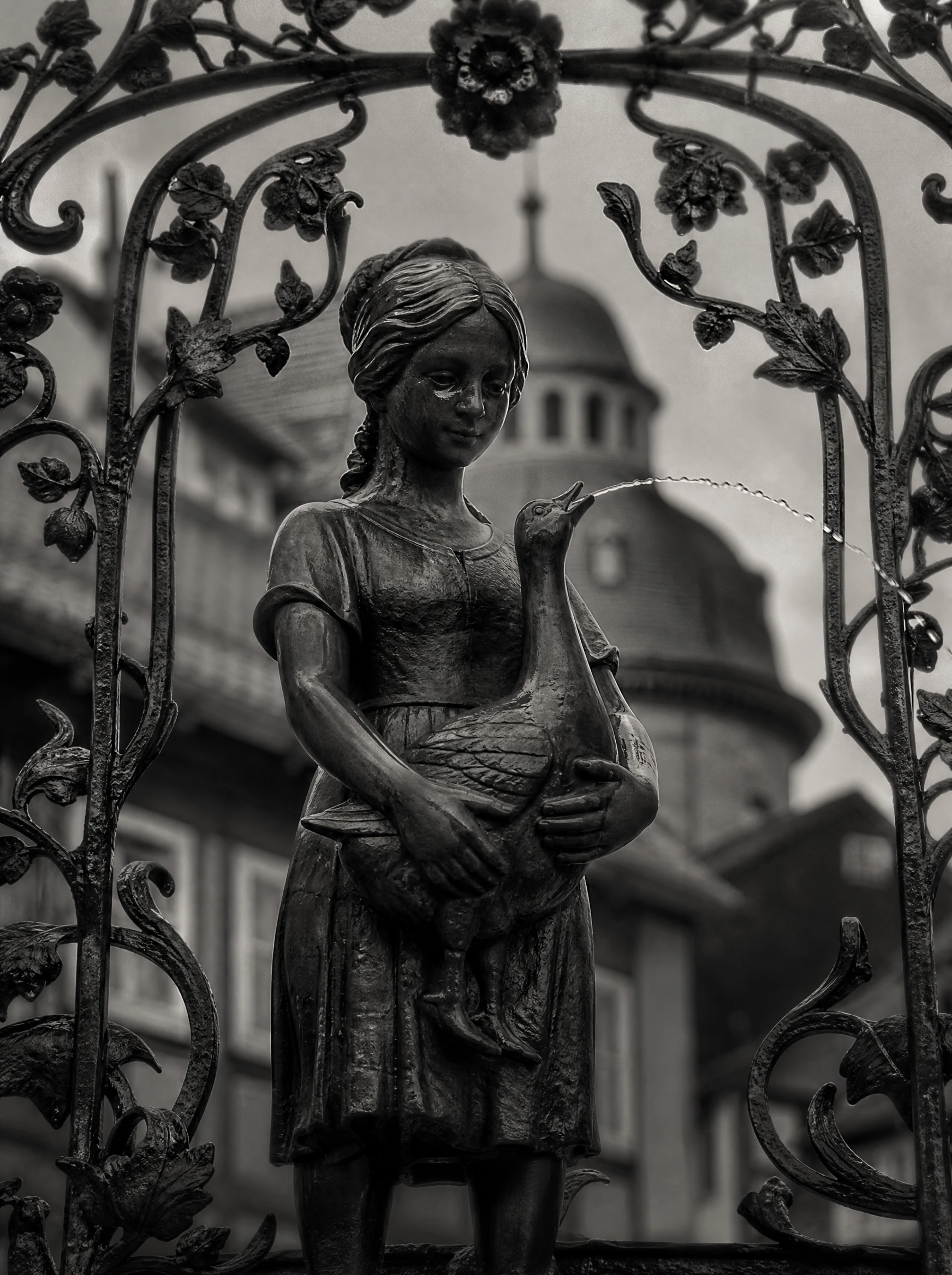 Primo piano di scultura storica di fontana con delicato getto d’acqua