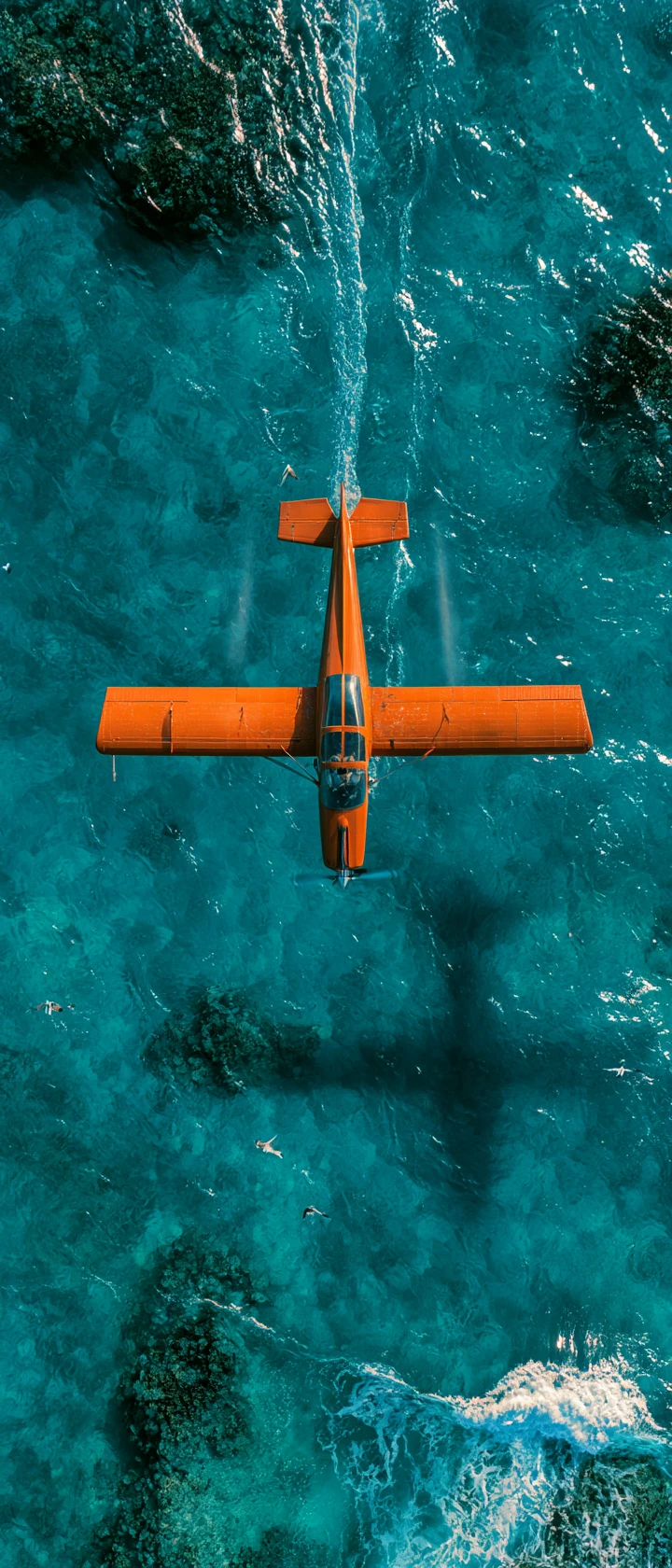 Avião vintage laranja voando sobre oceano turquesa