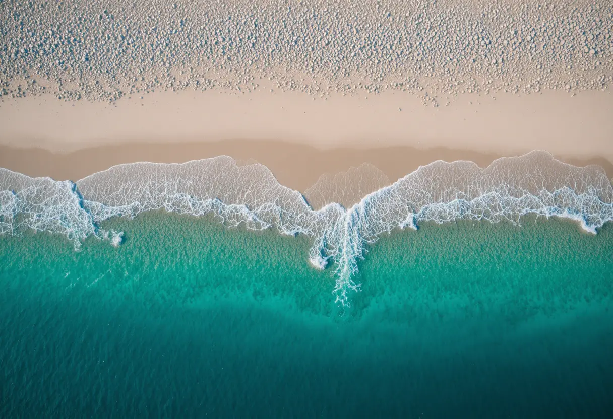 日落時俯瞰白色沙灘與碧綠海水的空拍景色