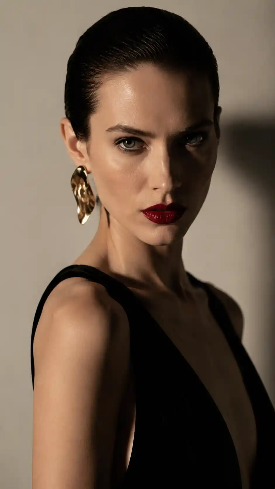 Elegant woman in black velvet gown with gold earring
