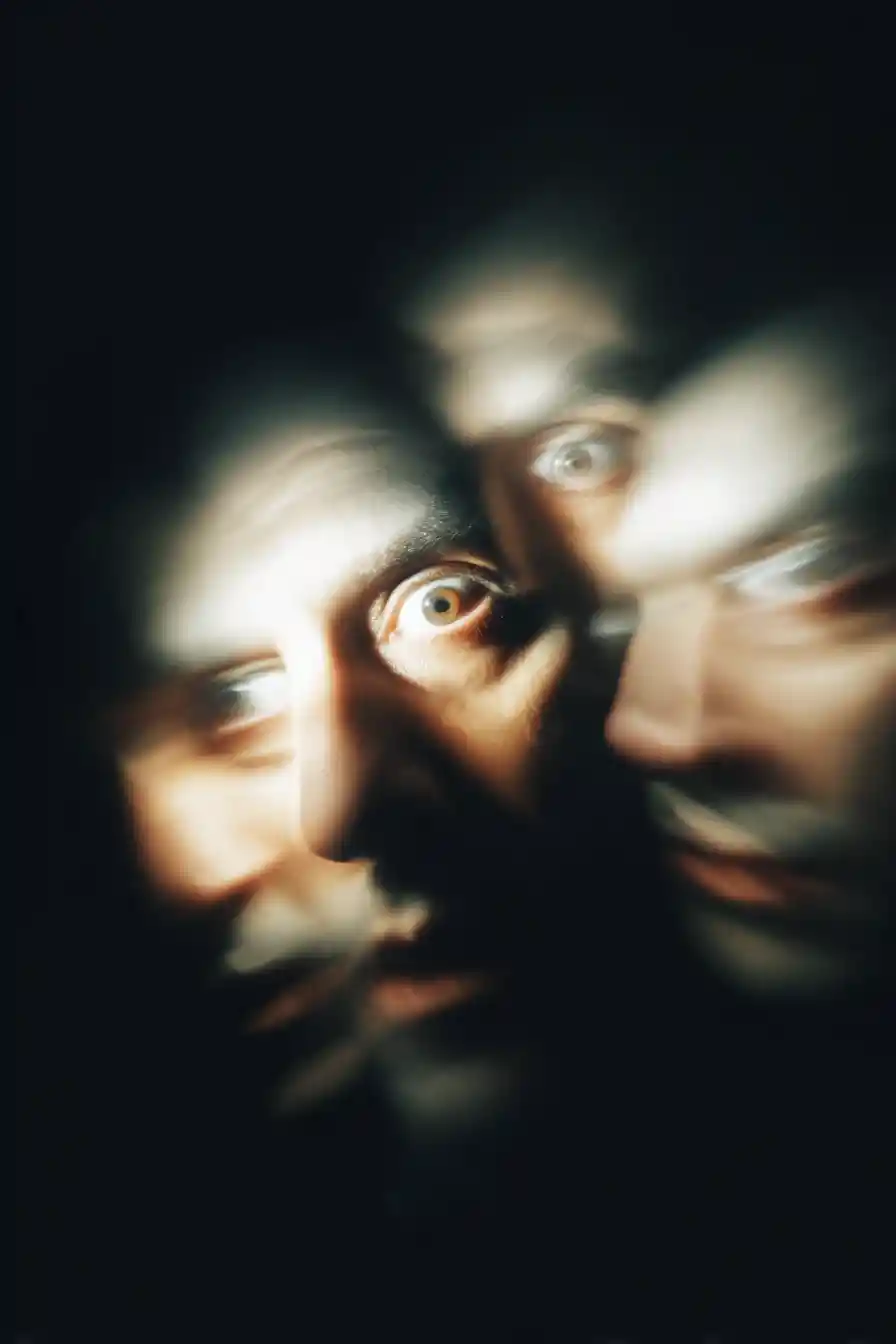 Verschwommenes Gesicht, das mit starren Augen in die Dunkelheit verblasst