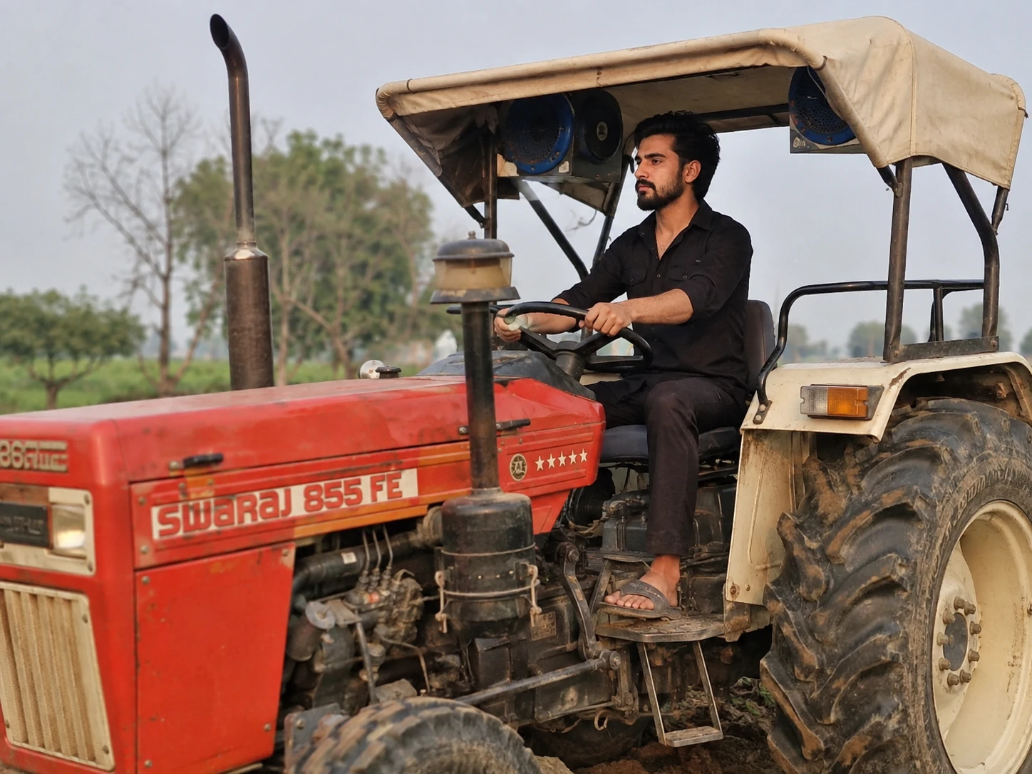 Homem dirigindo um trator em um campo agrícola rural