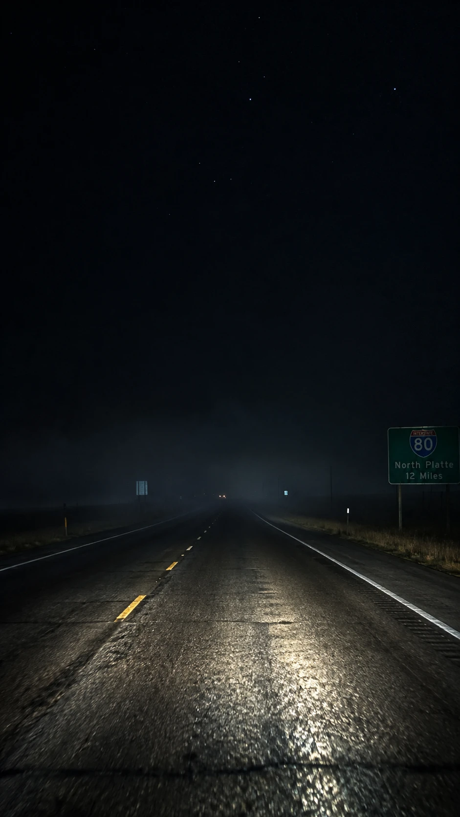 Lonely highway at night lit by distant car headlights
