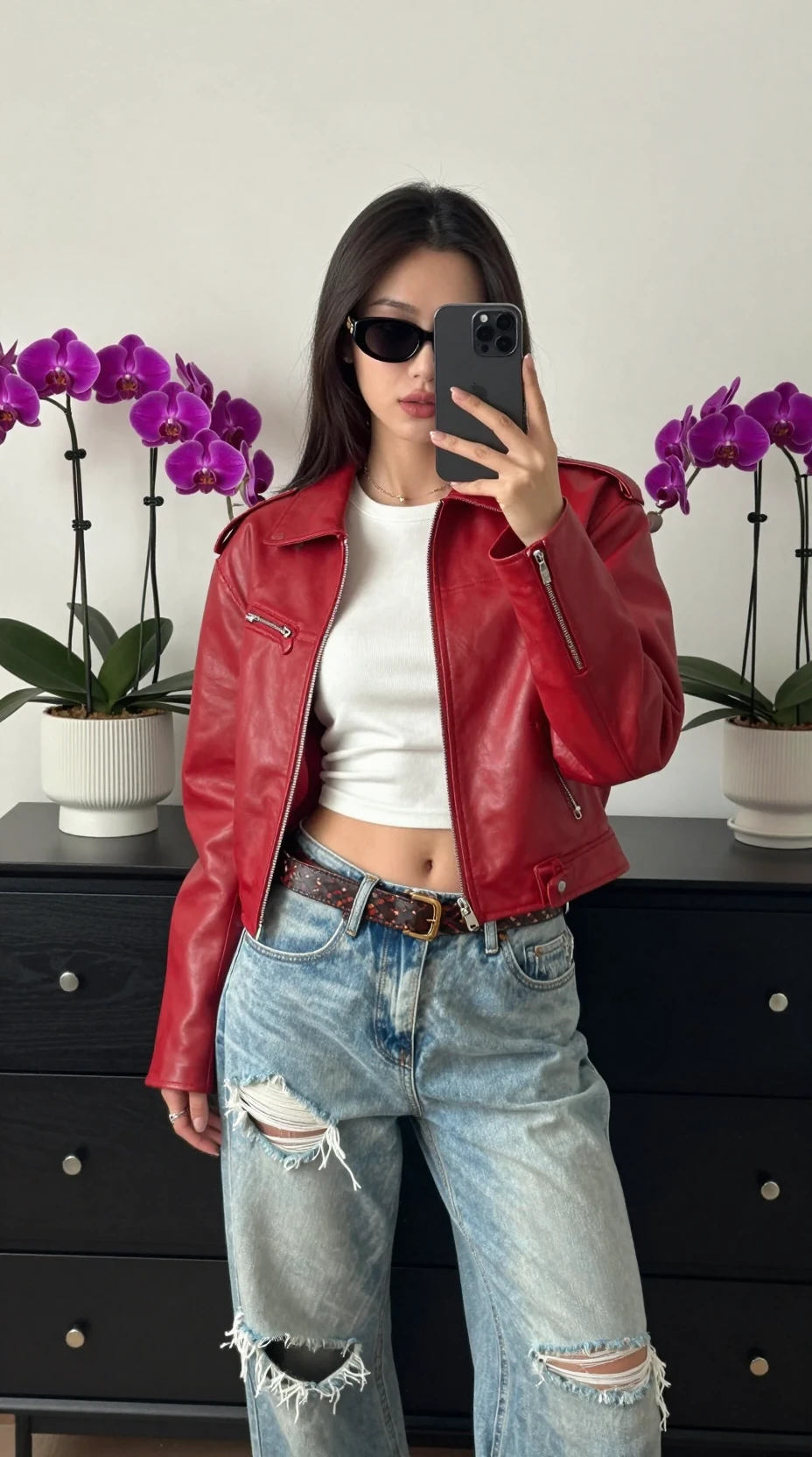 Uma mulher faz uma selfie estilosa no espelho usando uma jaqueta de couro vermelha