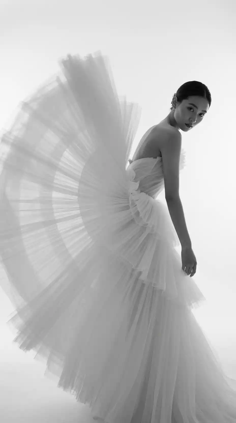 An East Asian Woman Turns in a Flowing Tulle Gown