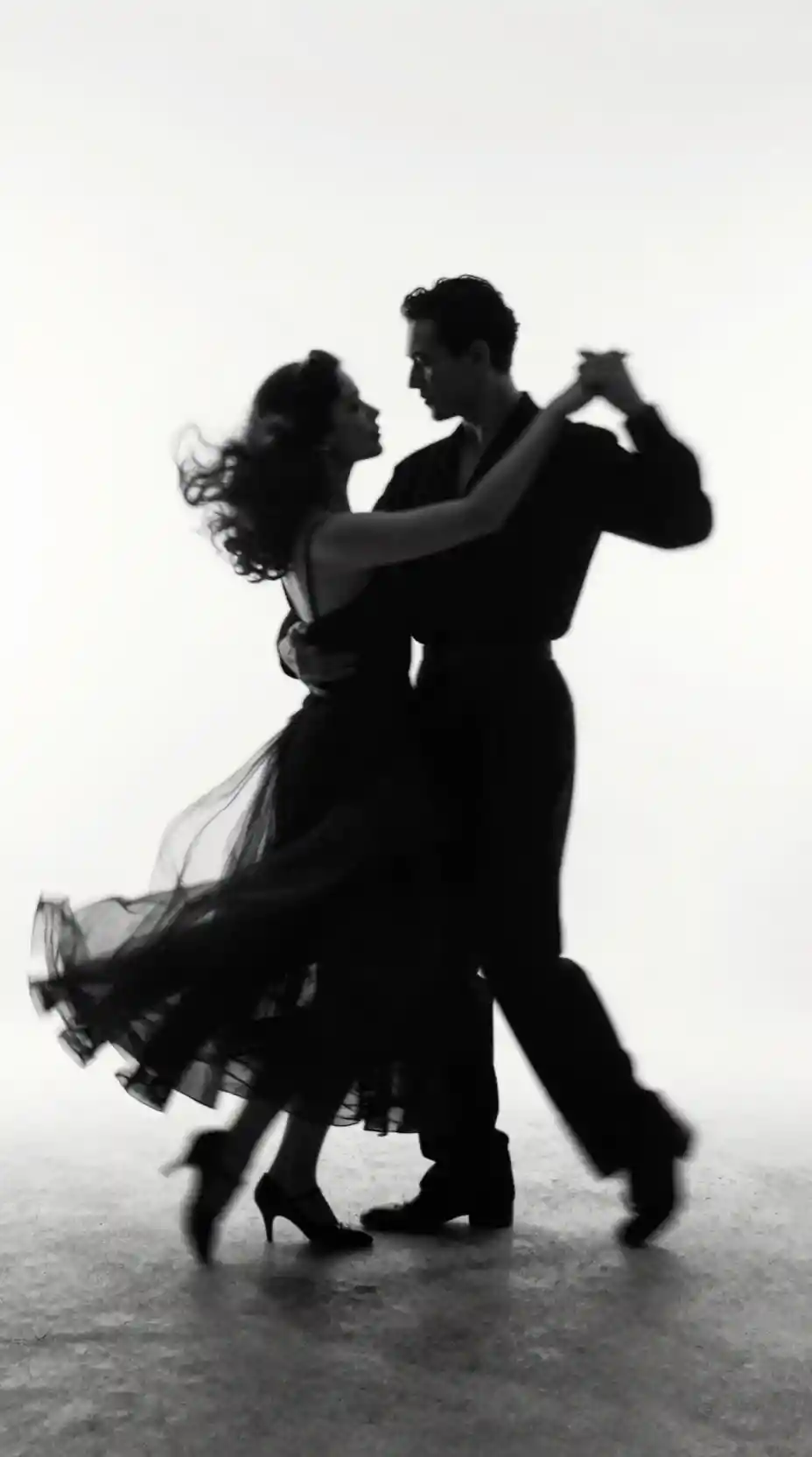 A dancing couple dissolves into swirling ash and dust on white